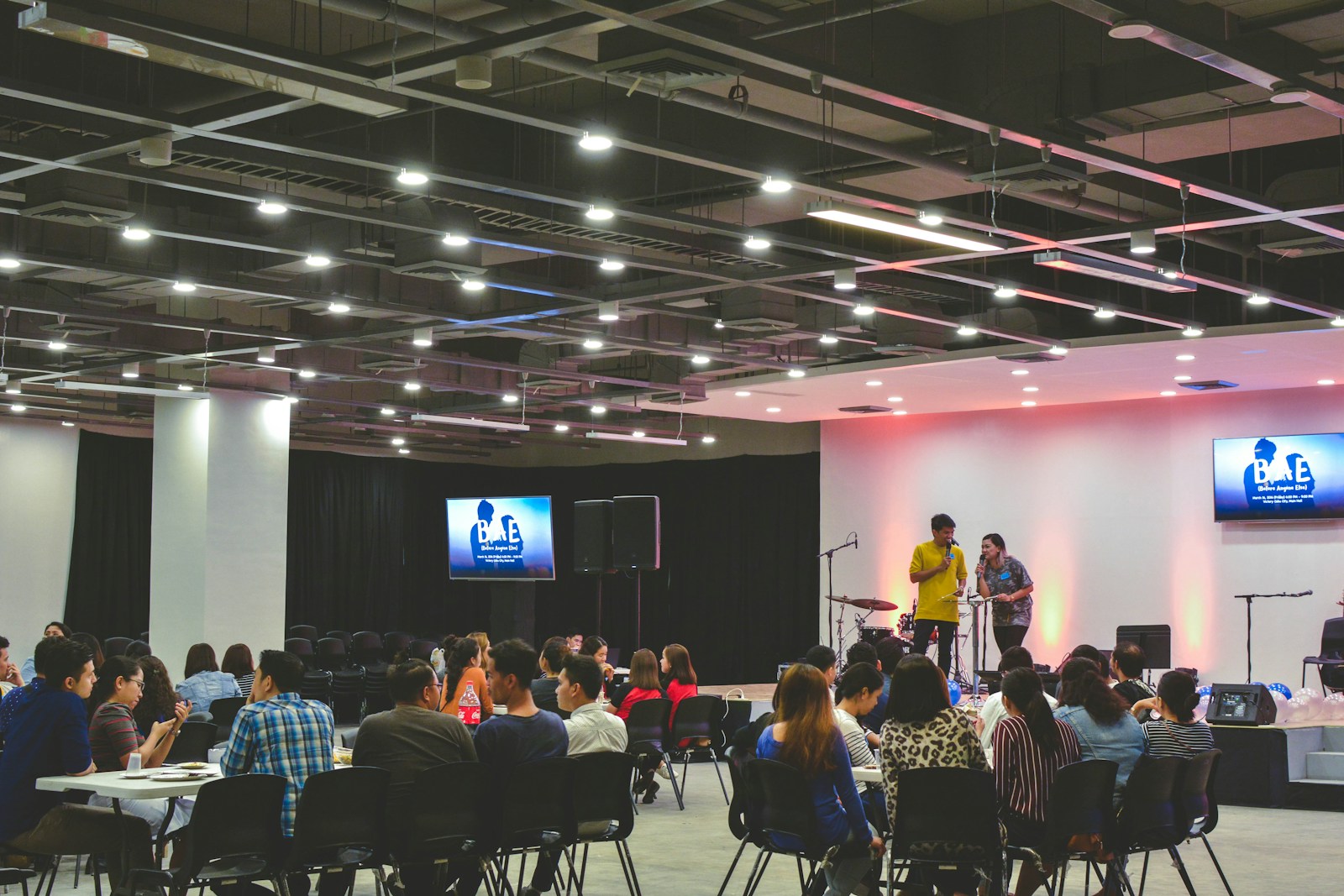 People seated at tables during an indoor gathering
